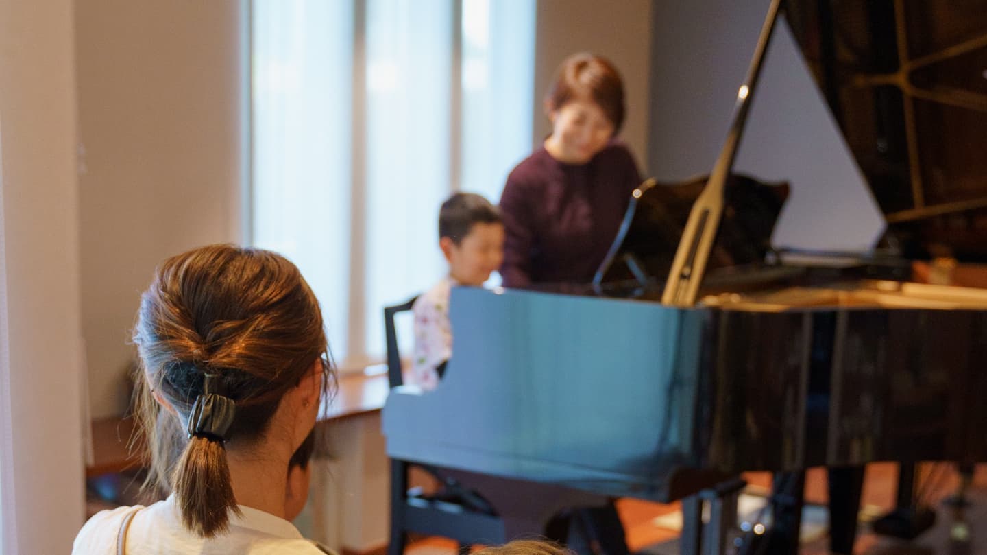 レッスンを受けている子どもを見学している親